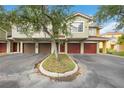 Exterior of a row of townhomes, each featuring its own garage and a well-kept landscaped median at 5691 Bentgrass Dr # 211, Sarasota, FL 34235