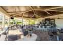 Spacious outdoor bar area with ample seating, granite countertops, ceiling fans, and a beautiful wood ceiling at 5811 Brandon Run, Bradenton, FL 34211