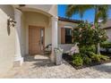 Charming front entrance with a covered porch, decorative plants, and a beautiful front door at 5917 Cessna Run, Lakewood Ranch, FL 34211