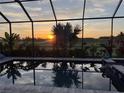 Screened-in pool offers a serene view of the golf course and a beautiful sunset at 5917 Cessna Run, Lakewood Ranch, FL 34211