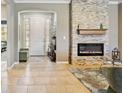 Bright living room features a stunning stone fireplace, tile floors, and elegant decor at 6381 Mighty Eagle Way, Sarasota, FL 34241