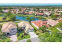Beautiful aerial view of homes in a community surrounding a tranquil pond, with lush landscaping at 6458 Tailfeather Way, Bradenton, FL 34203