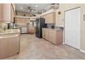 Spacious kitchen with stainless steel appliances, tile flooring, and light wood cabinetry at 686 Silk Oak Dr, Venice, FL 34293