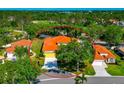 Aerial view of a single-story home with a terracotta roof, complemented by lush greenery and a well-maintained lawn at 7035 Owls Nest Ter, Bradenton, FL 34203