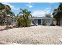 Charming exterior of home showcasing a low maintenance yard, mature landscaping, and inviting double door entry at 711 Birdsong Ln, Sarasota, FL 34242