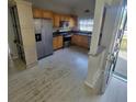 Traditional kitchen with stainless steel appliances, wood cabinets and white painted hardwood floors at 835 Indiana Ln, Sarasota, FL 34234