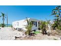 Single-story home featuring tidy landscaping, trees, and a nearby water view at 10315 Cortez W Rd # 8Bv, Bradenton, FL 34210