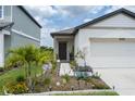 Charming home featuring a well-manicured lawn with colorful flowerbeds, and a welcoming front entrance at 10459 Ladybug Cove, Parrish, FL 34219