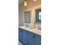 Elegant bathroom featuring a double vanity with contemporary fixtures, framed mirrors, and stylish lighting at 110 Pine Ave, Osprey, FL 34229