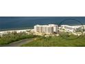Stunning aerial view of beachfront condo buildings with lush greenery and ocean views at 1104 Benjamin Franklin Dr # 519, Sarasota, FL 34236