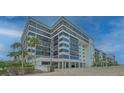 Modern condo exterior with large windows, palm trees, and ample parking at 1104 Benjamin Franklin Dr # 519, Sarasota, FL 34236