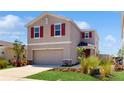 Stylish two-story home boasts red shutters, a well-manicured lawn, and a welcoming two-car garage at 11252 Fieldstone Dr, Palmetto, FL 34221