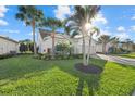 Landscaped yard with sunny exposure showcases the home's architectural detail and curb appeal at 11420 Golden Bay Pl, Bradenton, FL 34211