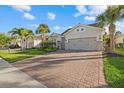 Inviting home with a brick driveway, lush landscaping, and an attached two-car garage at 11420 Golden Bay Pl, Bradenton, FL 34211