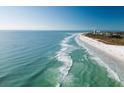 Scenic aerial view of a pristine white sand beach with turquoise water and a clear blue sky at 1240 Dolphin Bay Way # 304, Siesta Key, FL 34242