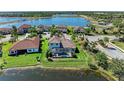 Aerial view of a home with a screened pool, fenced yard, and access to a scenic lake in a desirable area at 13107 Bridgeport Xing, Lakewood Ranch, FL 34211