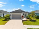 Charming single-story home featuring manicured landscaping, a two-car garage, and a welcoming entrance at 13487 Old Creek Ct, Parrish, FL 34219