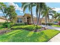 Charming single-story home featuring a tile roof, brick driveway, and tropical landscaping at 135 River Enclave Ct, Bradenton, FL 34212