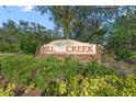 Mill Creek gated restricted community sign with lush greenery and stone accents at 14404 18Th E Pl, Bradenton, FL 34212