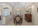 Formal dining room boasts elegant chandelier, decorative tray ceiling, and access to the front entrance at 14404 18Th E Pl, Bradenton, FL 34212