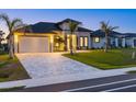 Striking one-story house with lush lawn, a two-car garage, and an interlocking brick driveway at 193 Rotonda N Blvd, Rotonda West, FL 33947