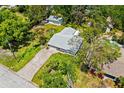 An aerial view of a charming home with a long brick driveway, lush greenery, and a detached garage at 2225 Alice Rd, Sarasota, FL 34231