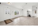 Bright living room with neutral tile floors, white walls, and archway, with a view of front yard at 2665 Chipley Ave, North Port, FL 34286