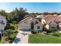 Aerial view of a well-maintained single-story home with tile roof, lush landscaping, and a manicured front lawn at 322 Langholm Dr, Venice, FL 34293