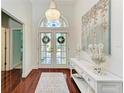 Bright foyer with hardwood floors, a chandelier, console table and beach-themed decorations at 322 Langholm Dr, Venice, FL 34293
