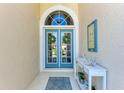 Inviting front entry with double doors, decorative wreaths, console table, and beach-themed decor at 322 Langholm Dr, Venice, FL 34293