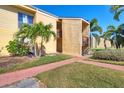 Two-story condo exterior featuring stucco facade, balcony, and tropical landscaping at 3457 Clark Rd # 156, Sarasota, FL 34231