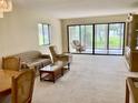 Bright living room featuring a large window offering plenty of natural light and neutral colored furniture at 3500 El Conquistador Pkwy # 129, Bradenton, FL 34210