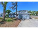 Charming two-story home features a blue exterior, well-manicured lawn, and attached garage at 404 62Nd Nw St, Bradenton, FL 34209