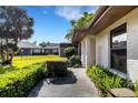 Landscaped walkway leading to a well-maintained home with mature trees and manicured bushes at 4463 Atwood Cay Pl # 22, Sarasota, FL 34233