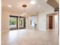 Bright dining room features elegant chandelier and large sliding glass doors leading to screened lanai and pool at 4915 Old Tree Pl, Sarasota, FL 34233