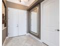 Elegant foyer with tiled floor, large mirror, and white doors at 4915 Old Tree Pl, Sarasota, FL 34233