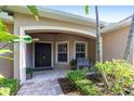 Inviting front porch featuring a double door entry, tile flooring, a bench, and manicured greenery for a welcoming entrance at 4915 Old Tree Pl, Sarasota, FL 34233