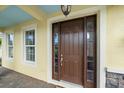 Inviting front entry with a dark wood door, sidelights, and a covered porch at 5522 Cartagena Dr, Sarasota, FL 34233