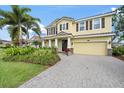Charming two-story home with yellow siding, brown shutters, manicured landscaping and a paver driveway at 5522 Cartagena Dr, Sarasota, FL 34233