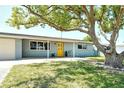 Inviting single-story home with a bright yellow front door and a meticulously kept lawn at 568 Sheridan Dr, Venice, FL 34293