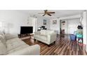 Bright living room featuring a ceiling fan, wood-look floors, and comfortable seating in a well-lit space at 6348 7Th W Ave # 6348, Bradenton, FL 34209