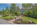Quaint home featuring a blue door, lush greenery, and a brick pathway at 640 N Osprey Ave, Sarasota, FL 34236