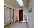 View of the foyer with brick-style tile flooring, skylight, and front door at 7340 Villa D Este Drive, Sarasota, FL 34238