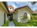 Home exterior showcasing the architecture, front entrance, landscaping, and natural light at 7340 Villa D Este Drive, Sarasota, FL 34238