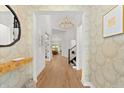 Bright foyer features decorative wallpaper, wood floors, modern lighting, and access to other rooms at 8163 Redonda Loop, Lakewood Ranch, FL 34202