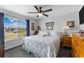 Cozy bedroom with a comfortable queen-sized bed, a large window view, and stylish ceiling fan at 8718 Gaillard Ave, North Port, FL 34287