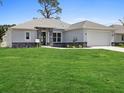 Charming single-story home with well-manicured lawn, stone accents, and a two-car garage at Lot 20 Garafola Ave, North Port, FL 34291