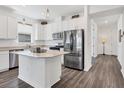 Modern kitchen with stainless steel appliances, center island, and bright, white cabinets at 10519 Spring Tide Way, Parrish, FL 34219
