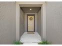 Inviting front entrance featuring a tan door adorned with a wreath and a neutral-colored mat at 11828 Sky Acres Ter, Bradenton, FL 34211