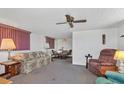 Inviting living room featuring neutral walls, carpeted flooring, and a ceiling fan at 1212 41St Avenue E Dr, Ellenton, FL 34222